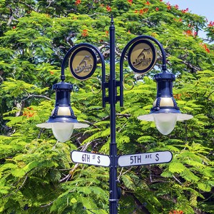 historical street sign in Naples, Florida under blue sky